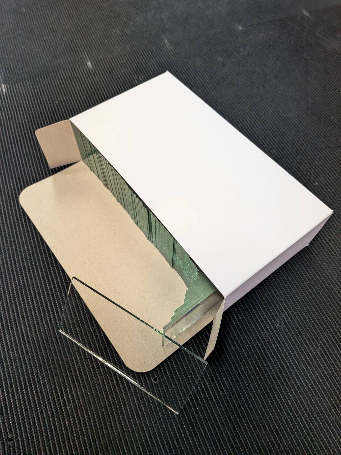 箱に詰めた溶接面用カバーガラス（白ガラス 2mm・101×50mm）